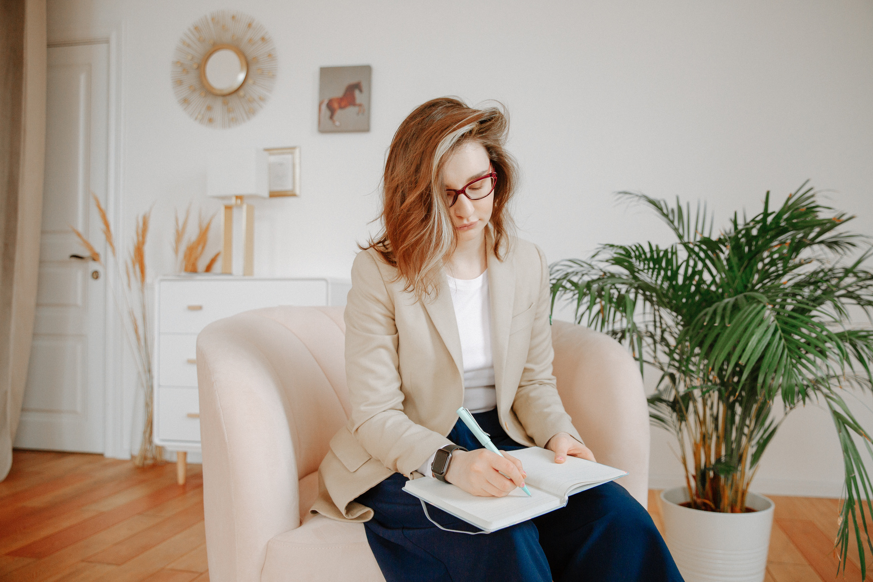 a person is sitting on a chair and writing in a notebook