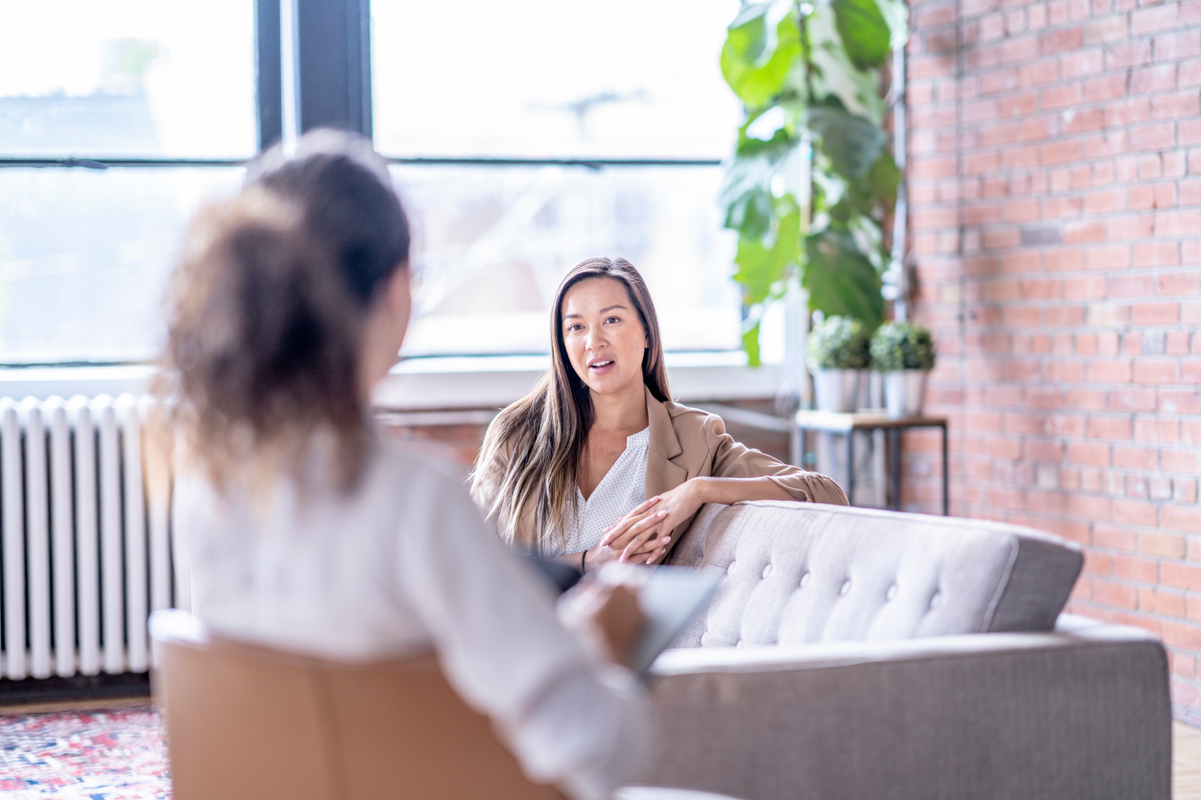 a person sitting on a couch talking to another person