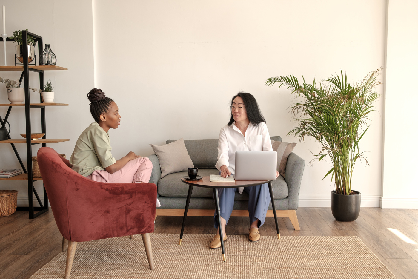 two people sitting in a living room with a laptop