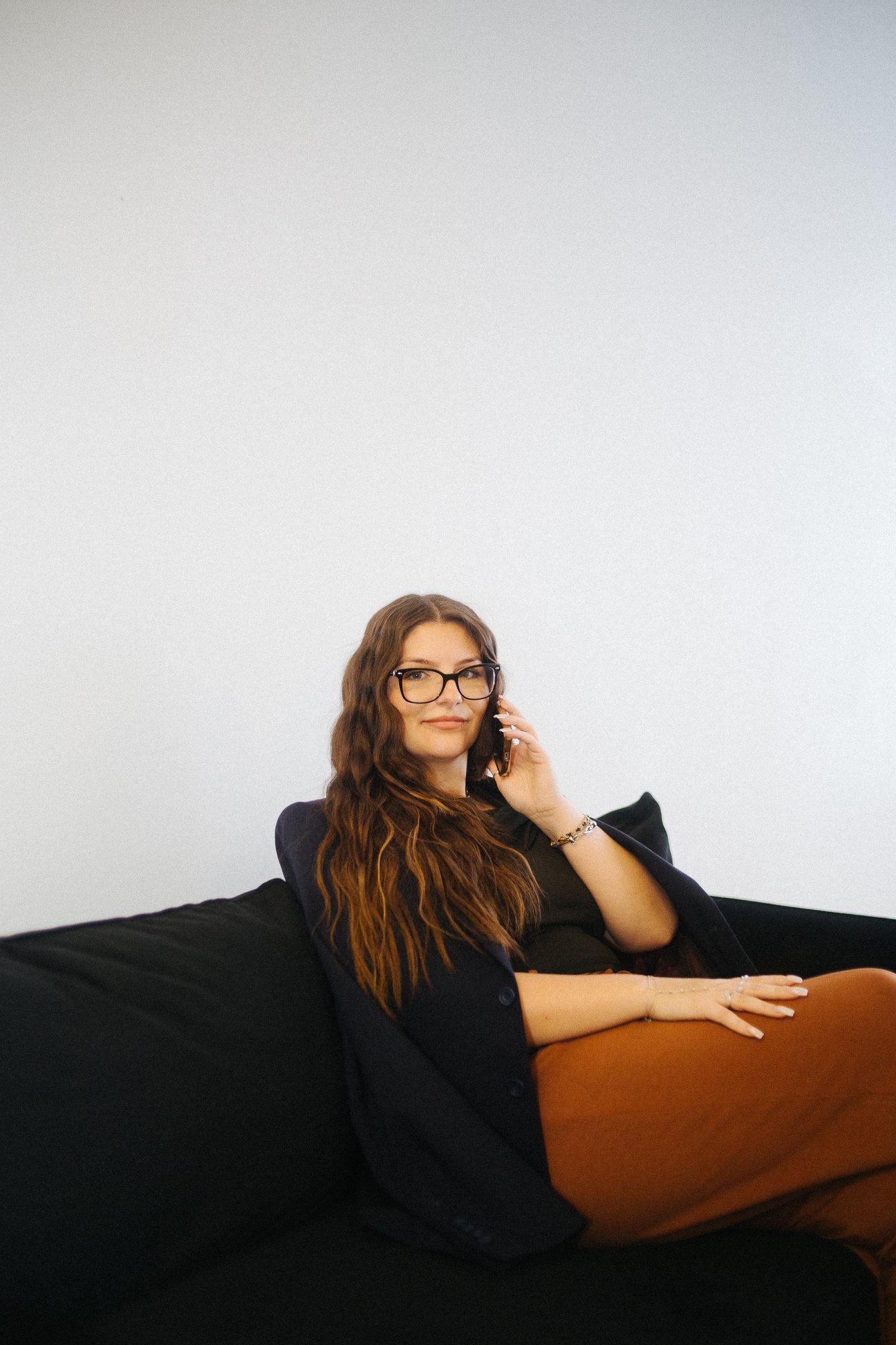 A person sitting on a couch talking on the phone