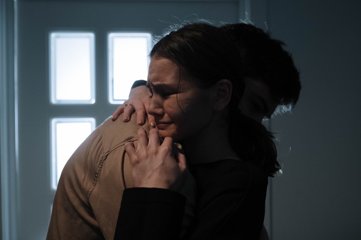 Two people embrace while one is crying.