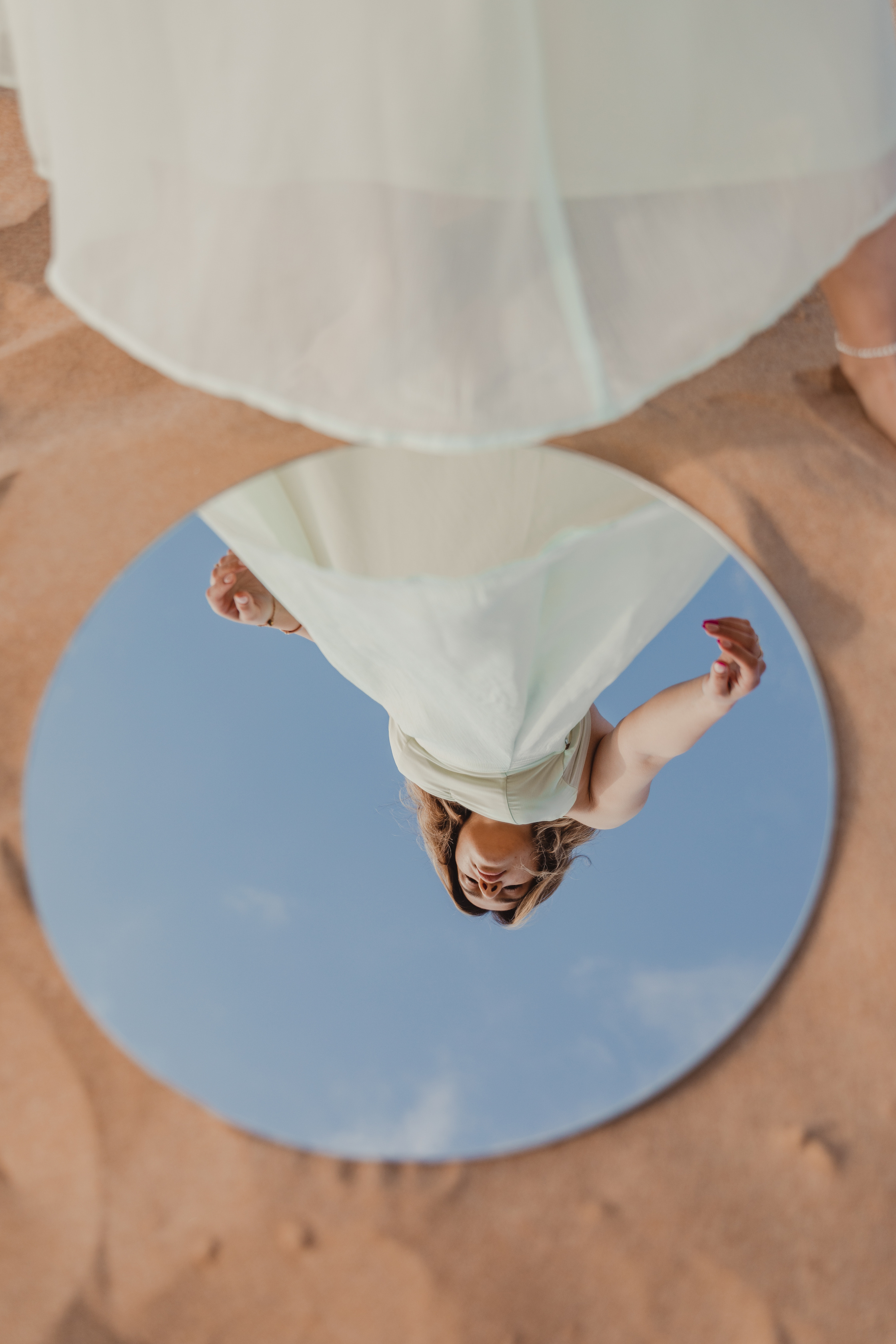 a person in a white dress is reflected in a mirror